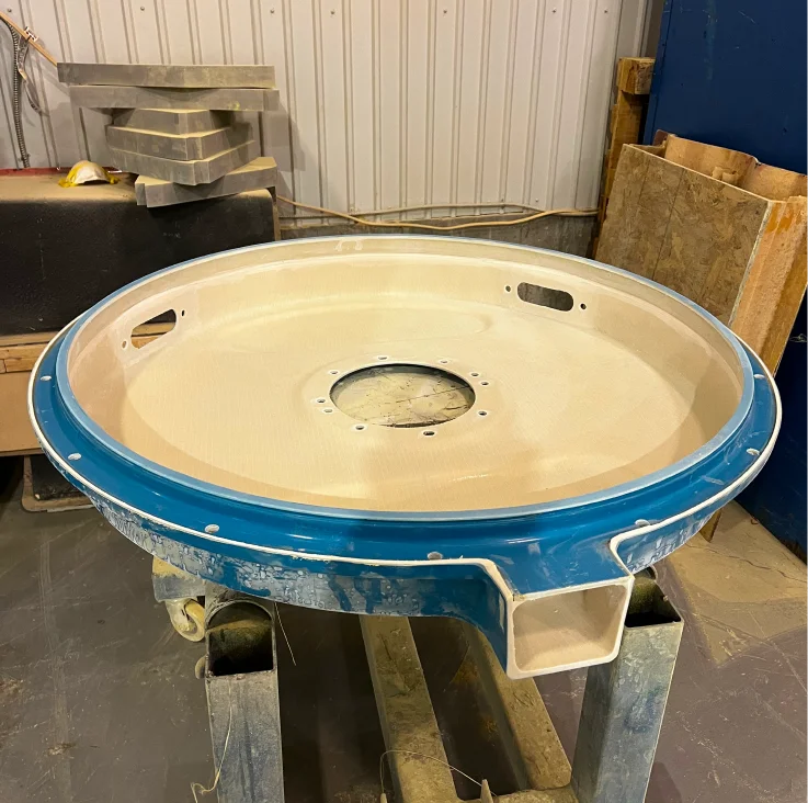 Pièce prototype circulaire en matériau composite avec bordure bleue chez HTM Composites